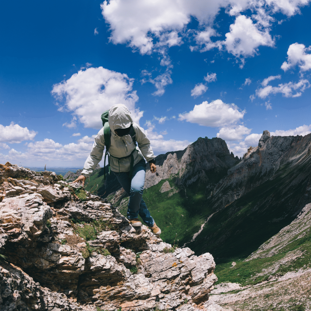 Successful woman backpacker hiking on alpine mountain top