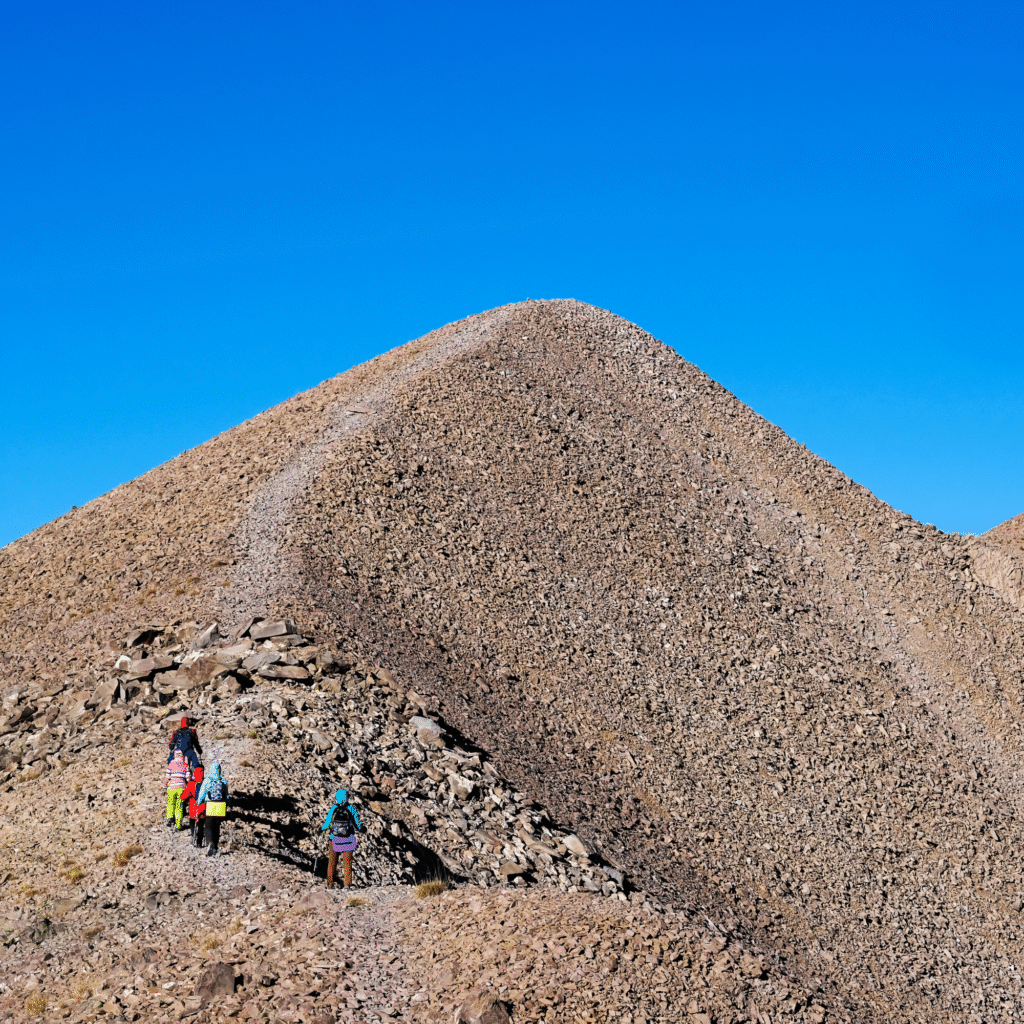 Group of hikers climbing stony mountains